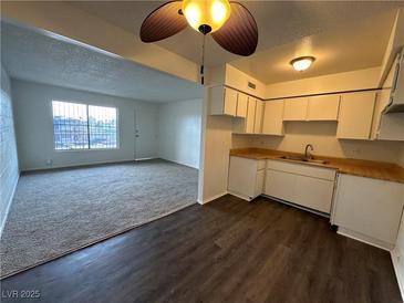 Bright kitchen features white cabinets and wood-look vinyl flooring at 585 S Royal Crest Cir # 21, Las Vegas, NV 89169