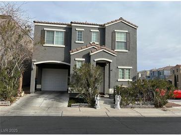 Two-story home featuring a two-car garage, neutral stucco exterior, and well-maintained landscaping at 6216 Pangea Ave, Las Vegas, NV 89139