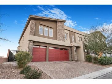 Two-story house with red garage doors and stone accents at 6407 Carmel Creek Ave, Las Vegas, NV 89139