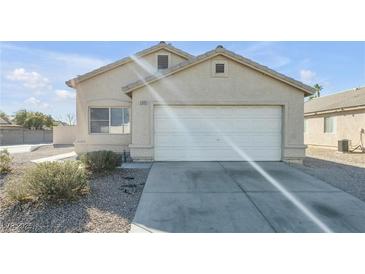 Single-story house with a white garage door and desert landscaping at 2005 Ona Marie Ave, North Las Vegas, NV 89032