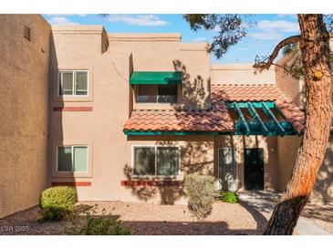 Tan two-story stucco townhouse with green awning and tile roof at 6750 Del Rey Ave # 122, Las Vegas, NV 89146