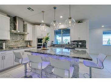 Modern kitchen with granite counters, stainless steel appliances, and an island at 6942 Alexandrite Peak St, Las Vegas, NV 89148