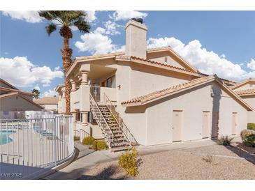 Two story building with pool and palm trees at 1013 Falconhead Ln # 101, Las Vegas, NV 89128