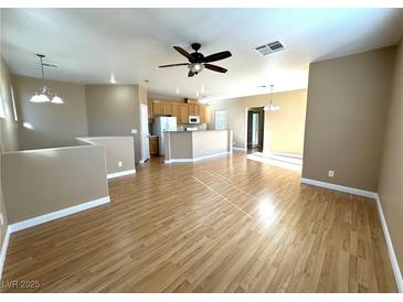 Bright living room with laminate wood floors and a view into the kitchen at 1350 Crystal Hill Ln # 3, Henderson, NV 89012