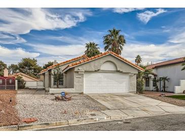 Charming single-story home featuring a two-car garage, desert landscaping, and a tile roof at 2668 Alwoodley Cir, Las Vegas, NV 89142