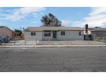 Single-story home with a fenced front yard and neutral color scheme at 3883 Seedling Way, Las Vegas, NV 89115