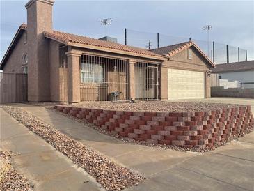 Single-story house with a two-car garage and landscaped yard at 609 W Victory Rd, Henderson, NV 89015