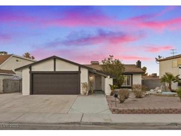 Single-story home with a two-car garage and landscaped front yard at 7134 Grasswood Dr, Las Vegas, NV 89147