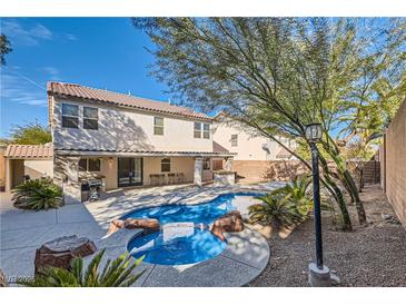 Gorgeous backyard pool and spa with desert landscaping, outdoor kitchen, and covered patio at 11276 Accademia Ct, Las Vegas, NV 89141