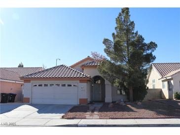 Single-story house with a two-car garage and landscaped front yard at 1235 Pagentry Dr, North Las Vegas, NV 89031