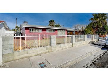 Ranch style home with a red brick exterior and a fenced front yard at 2105 Berkley Ave, Las Vegas, NV 89101