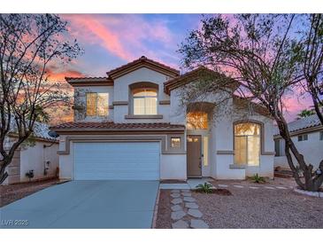 Two-story house with a landscaped front yard, driveway, and attached garage at dusk at 295 Blackstone River Ave, Las Vegas, NV 89148