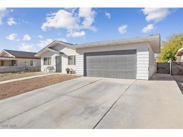 Ranch style home with gray garage door and landscaped yard at 4027 Boratko St, Las Vegas, NV 89115