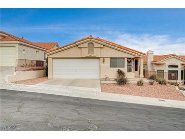 Single-story house with a tan stucco exterior, red tile roof, and a two-car garage at 408 Matecumbe Way, Boulder City, NV 89005