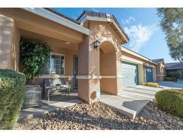 Inviting front porch with seating area, two-car garage, and landscaped yard at 5370 Cholla Cactus Ave, Las Vegas, NV 89141