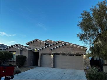 Two-story house with three-car garage and desert landscaping at 8318 Saddleback Ledge Ave, Las Vegas, NV 89147