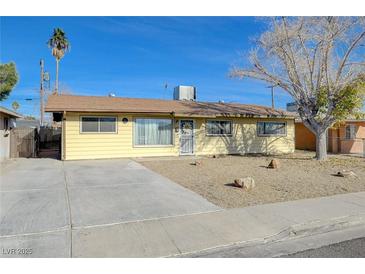 Charming single-story home featuring a spacious front yard and a long concrete driveway at 1212 Reynolds Ave, North Las Vegas, NV 89030