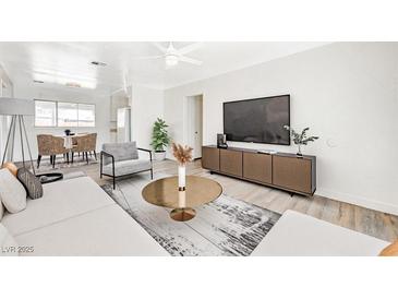 Bright living room with comfy seating and a large TV at 1212 Reynolds Ave, North Las Vegas, NV 89030