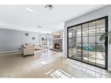 Bright living room features a fireplace and sliding glass doors leading to a patio at 2039 Waverly Cir, Henderson, NV 89014