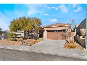 Single-story house with a brown garage door and landscaped front yard at 2568 Dirleton Pl, Henderson, NV 89044