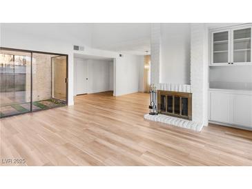 Bright living room with fireplace and sliding glass doors leading to a private patio at 2620 San Martin Ct, Las Vegas, NV 89121