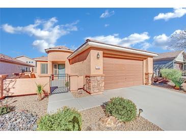 Single-story house with tan exterior, two-car garage, and landscaped yard at 2736 Mintlaw Ave, Henderson, NV 89044