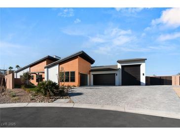 Modern home with two-tone exterior, paved driveway, and landscaped desert front yard at 6385 Leeland Ct, Las Vegas, NV 89149