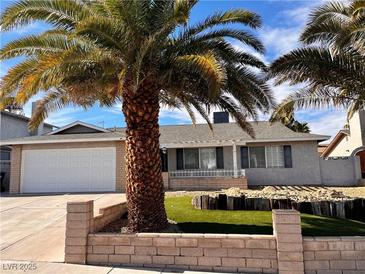 Single story home with a white garage door and landscaped front yard at 730 Brick Dr, Henderson, NV 89002