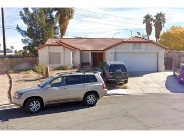 Single-story house with red tile roof, attached garage, and driveway at 8072 Hackberry Dr, Las Vegas, NV 89123