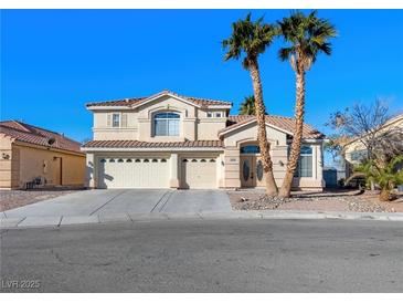 Two-story house with three-car garage and desert landscaping at 9307 Bondeno St, Las Vegas, NV 89123