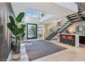 Bright entry with high ceilings, modern staircase, and stylish seating area at 103 San Martino Pl, Henderson, NV 89011