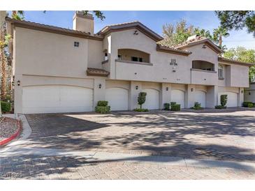 Tan two-story building with attached garages and landscaping at 113 Emerald Forest St # 203, Las Vegas, NV 89145