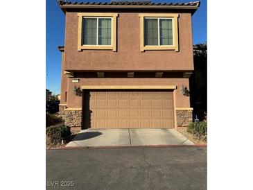 Two-story house with attached garage and light brown exterior at 616 Taliput Palm Pl, Henderson, NV 89011