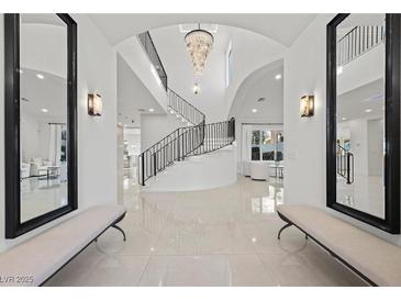 Grand foyer features tile flooring, soaring ceilings, custom lighting and a curved staircase at 9605 Verlaine Ct, Las Vegas, NV 89145