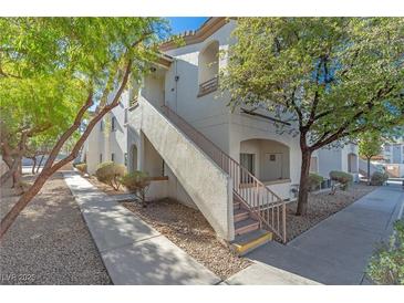 Exterior view of a light-colored building with stairs and landscaping at 5650 E Sahara Ave # 1012, Las Vegas, NV 89142