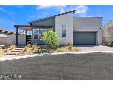 Modern single Gathering home featuring a two-car garage, drought-tolerant landscaping, and a neutral color palette at 10301 Fairview Ridge Ct, Las Vegas, NV 89166