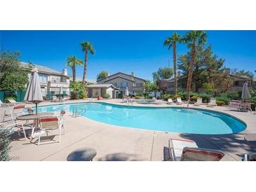 Inviting community pool with lounge chairs and patio tables at 5710 E Tropicana Ave # 2017, Las Vegas, NV 89122