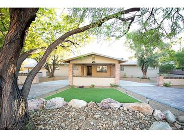 Ranch style home with landscaped yard, brick accents and large trees at 749 Rossmore Dr, Las Vegas, NV 89110
