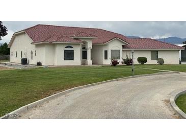 A charming single-story home with stucco exterior, tile roof, and well-manicured lawn at 390 China St, Pahrump, NV 89048