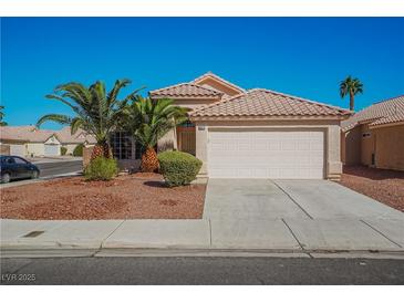 Single-story house with a two-car garage and desert landscaping at 5012 Camino Del Rancho, Las Vegas, NV 89130