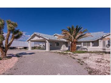 Single-story house with carport, palm tree, and gravel driveway at 5271 Deanna St, Pahrump, NV 89048