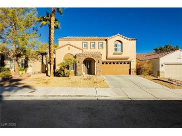 Two-story house with tan exterior, stone accents, and a three-car garage at 9904 Garamound Ave, Las Vegas, NV 89117