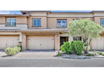 Tan two-story townhome with attached garage and landscaping at 10375 Pescado Ln, Las Vegas, NV 89135
