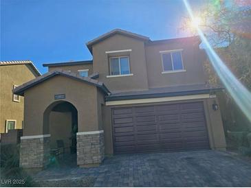 Two-story house with a brown brick facade, a large garage, and a paved driveway at 181 Elexese Ct, Las Vegas, NV 89183