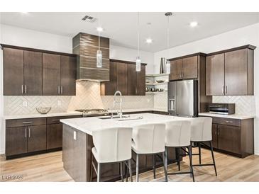 Modern kitchen featuring a large island, stainless steel appliances, and stylish pendant lighting at 52 Reverie Heights Ave, Henderson, NV 89011