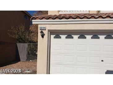 White two-car garage with opener and address number visible at 6684 Coronado Crest Ave, Las Vegas, NV 89139