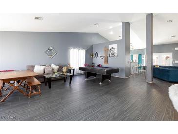 Spacious living room with pool table, comfy seating, and a large TV at 207 Charter Oak St, Henderson, NV 89074