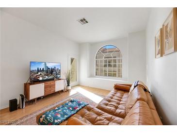 Bright living room with a leather sectional sofa and large TV at 3125 N Buffalo Dr # 2136, Las Vegas, NV 89128