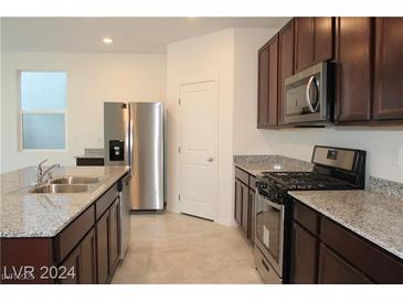 Modern kitchen with stainless steel appliances and granite countertops at 7001 Sylmar Ave, Las Vegas, NV 89113