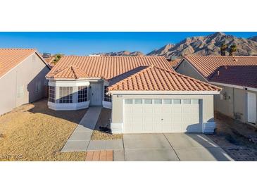 Single-story house with tile roof, two-car garage, and desert landscaping at 2594 Florida Keys Dr, Las Vegas, NV 89156
